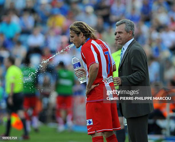 Atletico de Madrid's Mexican head coach Javier Aguirre gives instructions to Uruguayan forward Diego Forlan during a Spanish Liga football match...