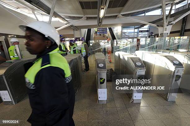 Employees walk at the Marlboro station built for the Gautrain, South Africa's first high-speed train, in Johannesburg on May 6, 2010. The line will...