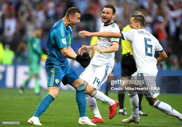 Igor Akinfeev of Russia celebrates victory with team mates Denis Cheryshev and Vladimir Granat during the 2018 FIFA World Cup Russia Round of 16...