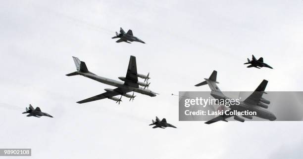 Tanker Il-78M is refueling strategic bomber Tu-95 protected by jet fighters MiG-29. Russian military forces train for the Victory Day parade that...