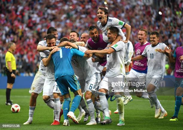 Igor Akinfeev of Russia is celebrated by team mates following the 2018 FIFA World Cup Russia Round of 16 match between Spain and Russia at Luzhniki...