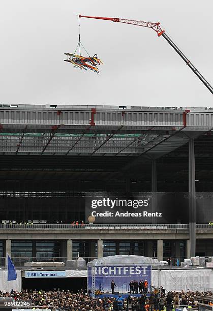 An aircraft shaped crown is lifted by a crane at the main terminal during the roofing ceremony at the new Airport Berlin Brandenburg International...