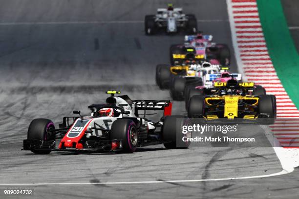 Kevin Magnussen of Denmark driving the Haas F1 Team VF-18 Ferrari leads Nico Hulkenberg of Germany driving the Renault Sport Formula One Team RS18 on...