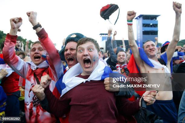 Russia fans react after Russia won the penalty shoot-out during the Russia 2018 World Cup round of 16 football match between Spain and Russia, while...