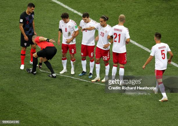 Referee Nestor Pitana marks a line for the Denmark wall to stand along as Croatia prepare to take a free kick during the 2018 FIFA World Cup Russia...