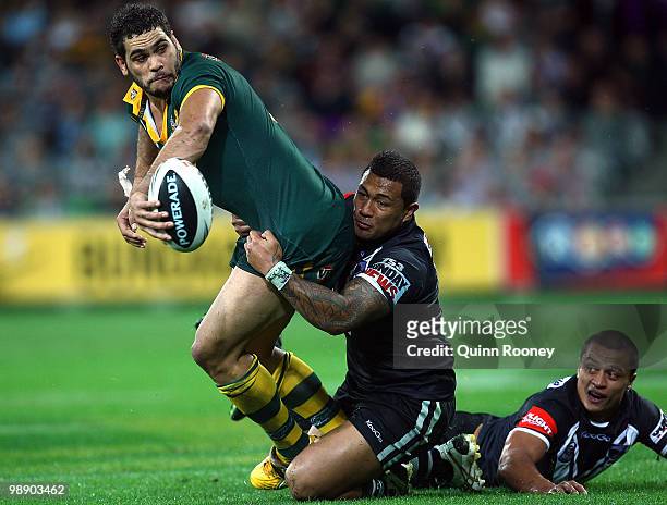 Greg Inglis of the Kangaroos passes the ball whilst being tackled during the ARL Test match between the Australian Kangaroos and the New Zealand...