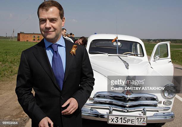 Russian President Dmitry Medvedev stands near a Gaz M-20 "Pobeda", or Victory, model automobile not far from Moscow in Dubosekovo on May 7, 2010...