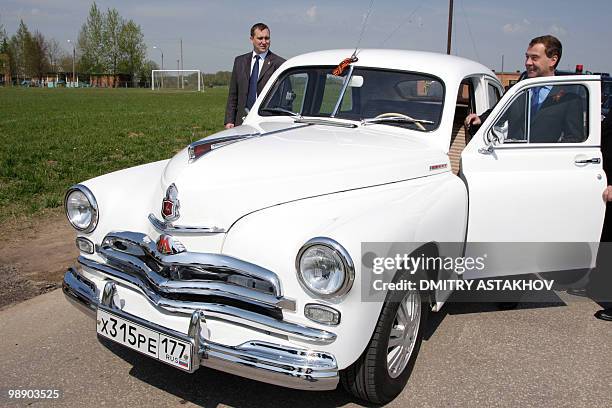Russian President Dmitry Medvedev opens the door of a Gaz M-20 "Pobeda", or Victory, model automobile not far from Moscow in Dubosekovo on May 7,...