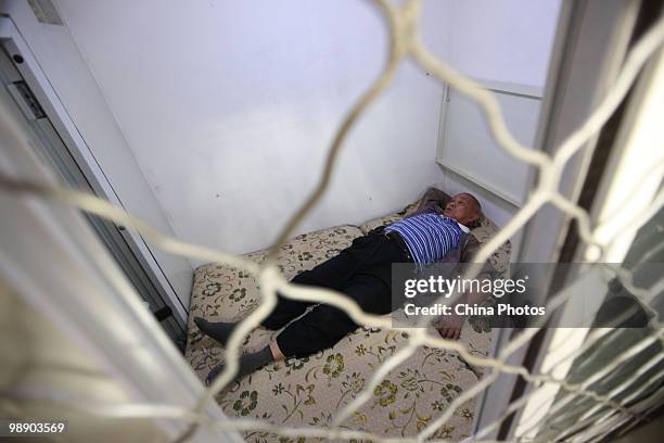 Chinese senior citizen Huang Rixin, a 78-year-old retired engineer, rests in his newly built 'deluxe version' of 'Capsule Apartments' on May 6, 2010...