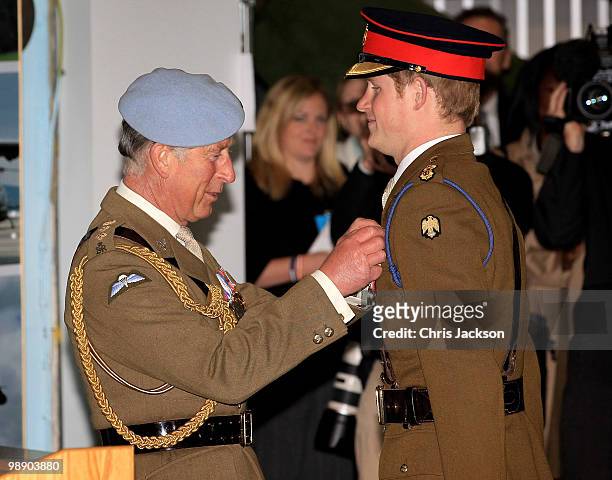 Prince Charles, Prince of Wales presents Prince Harry with his flying wings at Prince Harry's Pilot Course Graduation at the Army Aviation Centre on...