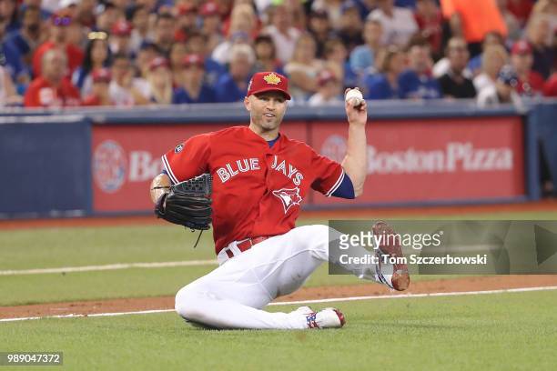 Happ of the Toronto Blue Jays cannot get the throw away after fielding an RBI bunt single by Leonys Martin of teh Detroit Tigers in the fifth inning...