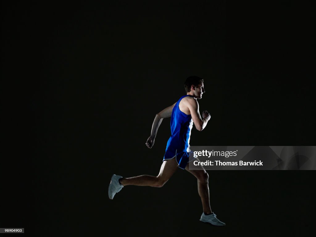 Male runner running mid stride in mid air