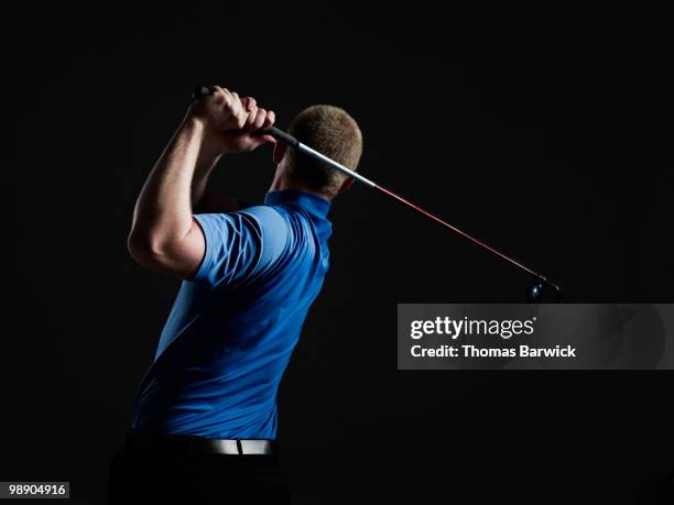 male golfer swinging club rear view - top golf stock pictures, royalty-free photos & images