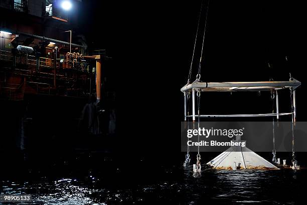 Cofferdam is lowered by the Helix Q4000 mobile offshore drilling unit to the seabed at the site of the former BP Plc Deepwater Horizon oil rig in the...