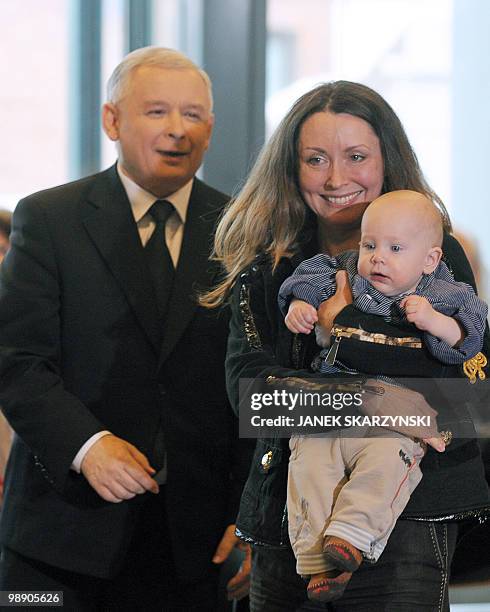 Woman and baby stand near Jaroslaw Kaczynski, leader of Poland's conservative PiS party who is running for president after his twin, late President...