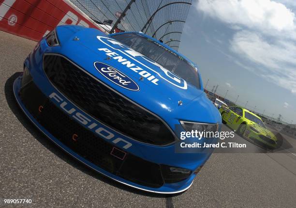 Ryan Blaney, driver of the PPG Ford, and Paul Menard, driver of the Menards/Sylvania Ford, lead the field prior to the start of the Monster Energy...