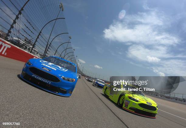 Paul Menard, driver of the Menards/Sylvania Ford, and Ryan Blaney, driver of the PPG Ford, lead the field prior to the start of the Monster Energy...