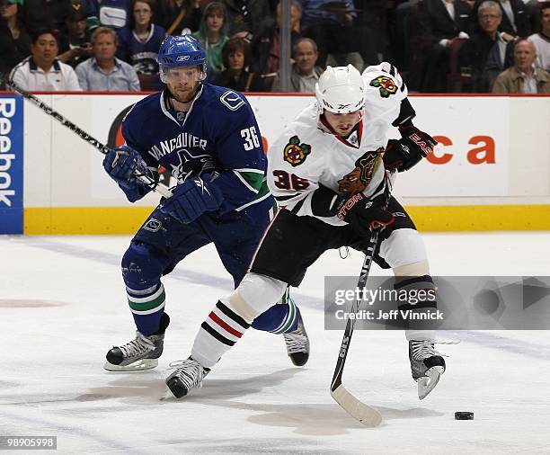 Jannik Hansen of the Vancouver Canucks tries to check Dave Bolland of the Chicago Blackhawks as he skates up ice in Game Three of the Western...