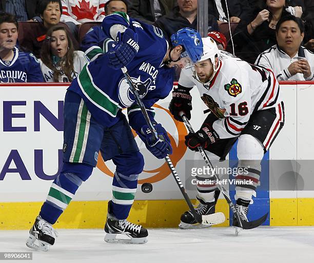 Andrew Ladd of the Chicago Blackhawks and Alex Burrows of the Vancouver Canucks sbattle for a loose puck in Game Three of the Western Conference...