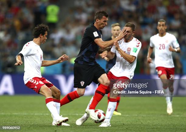 Mario Mandzukic of Croatia is challenged by Thomas Delaney and Jonas Knudsen of Denmark during the 2018 FIFA World Cup Russia Round of 16 match...