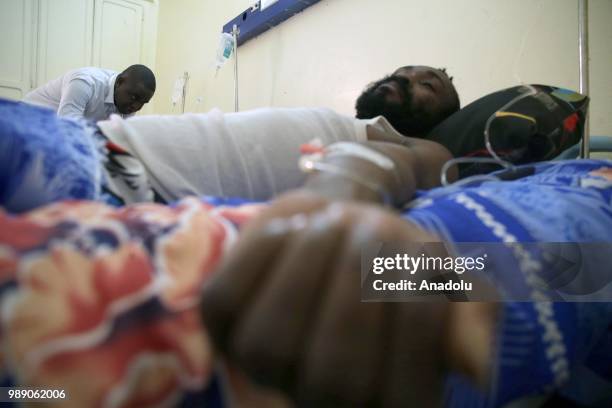 African migrant patients, who will be repatriated to their countries, lie on stretchers at Tamanrasset Hospital of the refugee camp located near the...