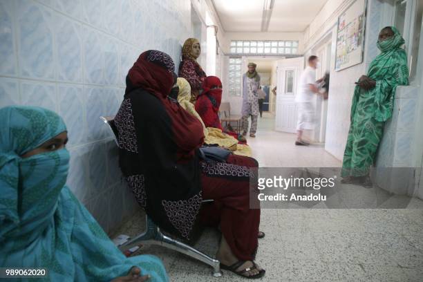 African migrant patients, who will be repatriated to their countries, wait to receive medical treatment at Tamanrasset Hospital of the refugee camp...