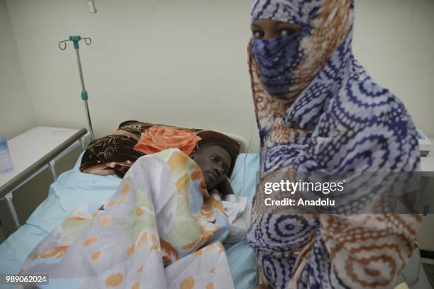 An African migrant patient, who will be repatriated to their countries, lies on a stretcher at Tamanrasset Hospital of the refugee camp located near...