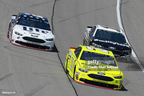 Paul Menard, driver of the Menards/Sylvania Ford, leads Brad Keselowski, driver of the Stars Stripes and Lites Ford, and Aric Almirola, driver of the...