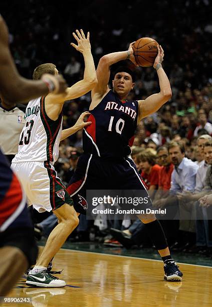 Mike Bibby of the Atlanta Hawks looks to pass under pressure from Luke Ridnour of the Milwaukee Bucks in Game Four of the Eastern Conference...