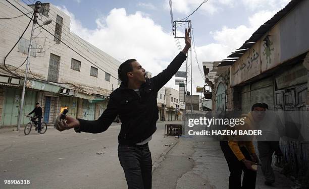 Palestinian youth throws a molotov cocktail bomb at Israeli soldiers during clashes in the West Bank town of Hebron on February 22, 2010....