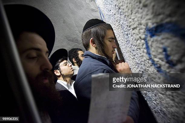 Ultra-Orthodox Jewish men pray at the tomb of the biblical Israeli leader Yehoshua bin Nun in the northern Palestinian village of Kifl Hareth in the...