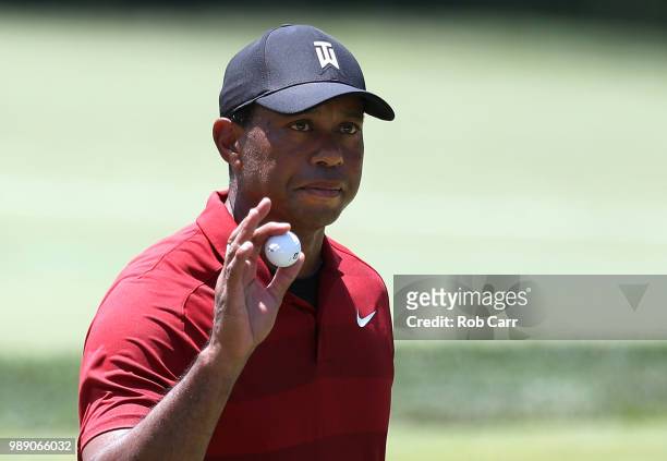 Tiger Woods reacts after a birdie putt on the second green during the final round of the Quicken Loans National at TPC Potomac on July 1, 2018 in...