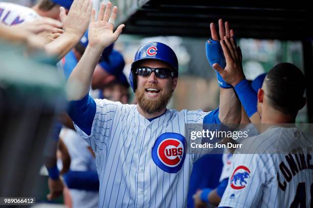 Ben Zobrist of the Chicago Cubs smiles as he is congratulated in the dugout after scoring against the Minnesota Twins on a two-run RBI double hit by...