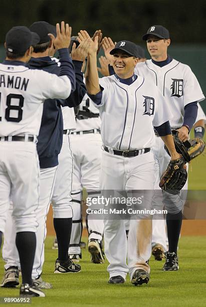 Magglio Ordonez of the Detroit Tigers high-fives teammates after the victory against the Minnesota Twins at Comerica Park on April 28, 2010 in...