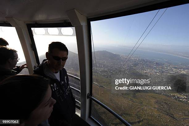 Tourists enjoy the landscape from a cable car on the Table mountain cableway on May 7, 2010 in Cape Town. Table Mountain cableway has been running...