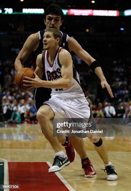 Luke Ridnour of the Milwaukee Buck drives past Zaza Pachulia of the Atlanta Hawks in Game Four of the Eastern Conference Quarterfinals during the...