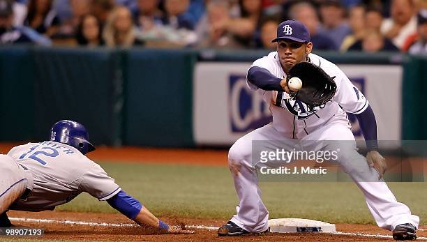 First baseman Carlos Pena of the Tampa Bay Rays takes the throw at first as Mitch Maier of the Kansas City Royals gets back safely during the game at...