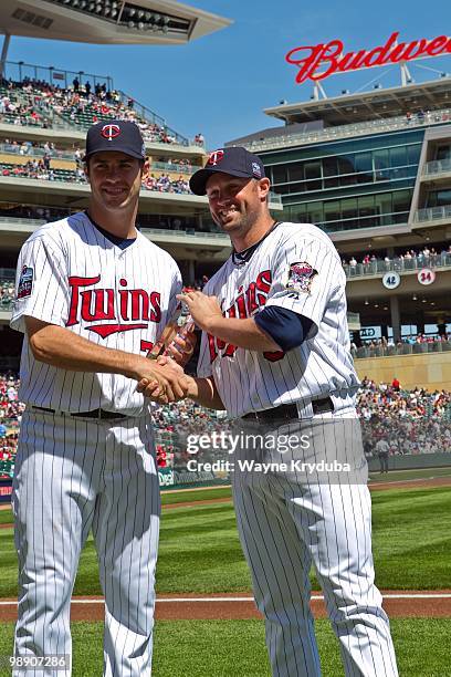Joe Mauer of the Minnesota Twins is presented with the Players Choice Award as the 2009 American League Outstanding Player by Michael Cuddyer before...