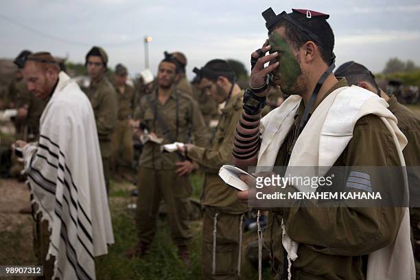 Israeli infantry soldiers of the army's Kfir brigade, wrapped with Jewish prayer shawls with phylacteries on their foreheads, pray early in the...