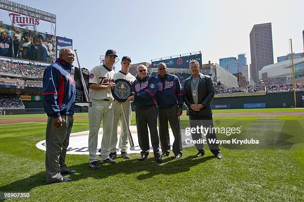 Joe Mauer of the Minnesota Twins is presented with the 2009 MVP award by former Minnesota Twin Harmon Killebrew before the game with the Kansas City...