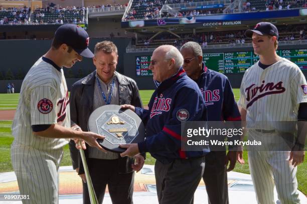 Joe Mauer of the Minnesota Twins is presented with the 2009 MVP award by former Minnesota Twin Harmon Killebrew before the game with the Kansas City...