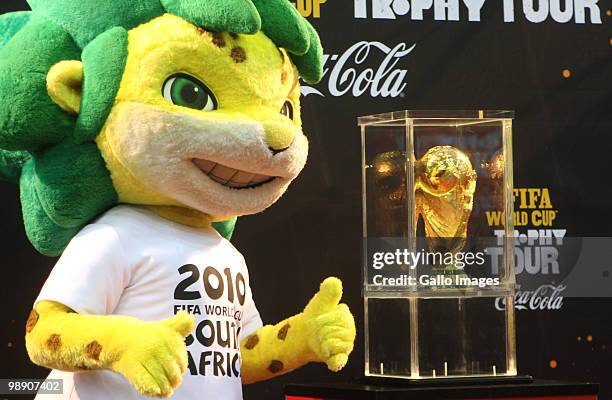 The 2010 FIFA World Cup mascotte, Zakumi, poses with the FIFA world cup trophy during the kick off of its South African tour in Kayelitsha on May 07,...