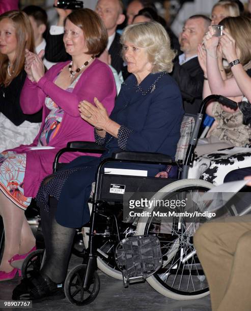 Camilla Duchess of Cornwall sits in a wheelchair, after breaking her leg whilst walking in Scotland, as she attends HRH Prince Harry's Army Air Corps...