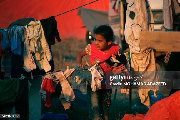 Displaced Syrian child from the Daraa province fleeing shelling by pro-government forces waits in a makeshift camp to cross the Jordanian border,...
