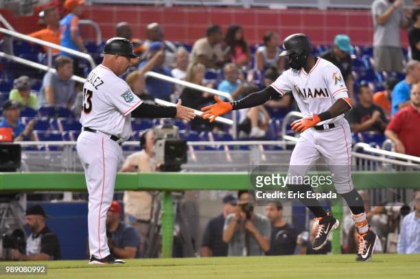 Cameron Maybin of the Miami Marlins is congratulated by third base coach Fredi Gonzalez after hitting a home run in the eighth inning against the New...