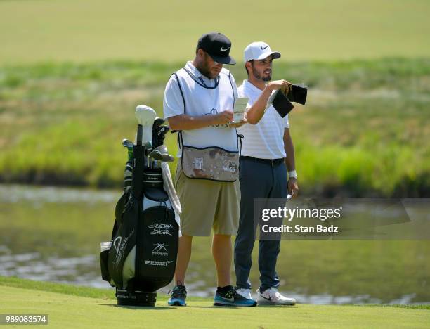 Abraham Ancer of Mexico checks his yardage on the fourth hole during the final round of the Quicken Loans National at TPC Potomac at Avenel Farm on...