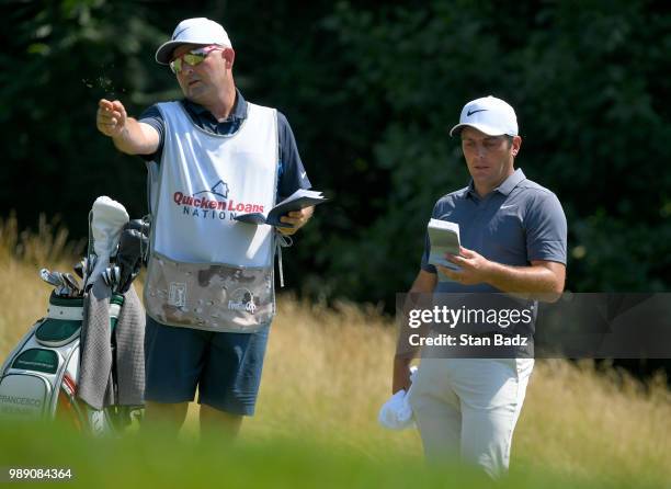 Francesco Molinari of Italy studies his yardage book on the third hole during the final round of the Quicken Loans National at TPC Potomac at Avenel...