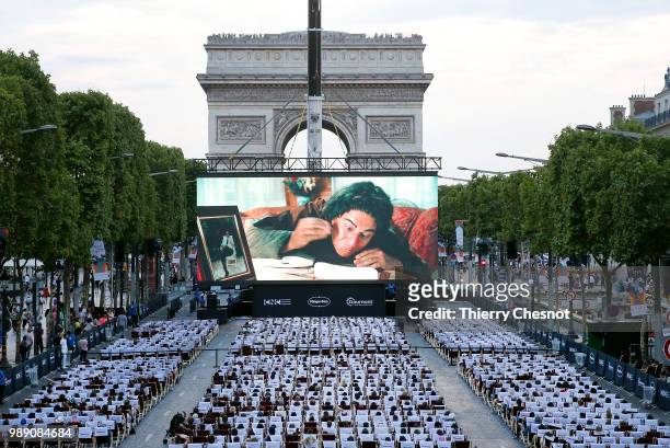 People watch the projection of the movie "Les Visiteurs" during the event "A Sunday at the Cinema" on the Avenue des Champs-Elysees on July 1, 2018...