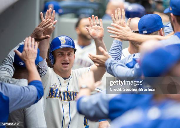 Kyle Seager of the Seattle Mariners is congratulated by teammates in the dugout after scoring a run on a single by Ben Gamel of the Seattle Mariners...