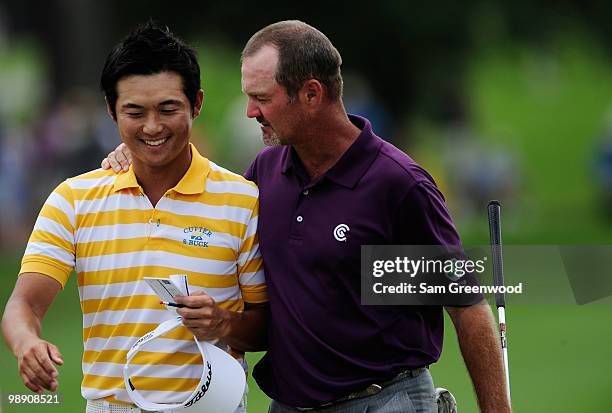 Ryuji Imada of Japan talks with Jerry Kelly on the 18th green after shooting a six-under-par 66 during the second round of THE PLAYERS Championship...